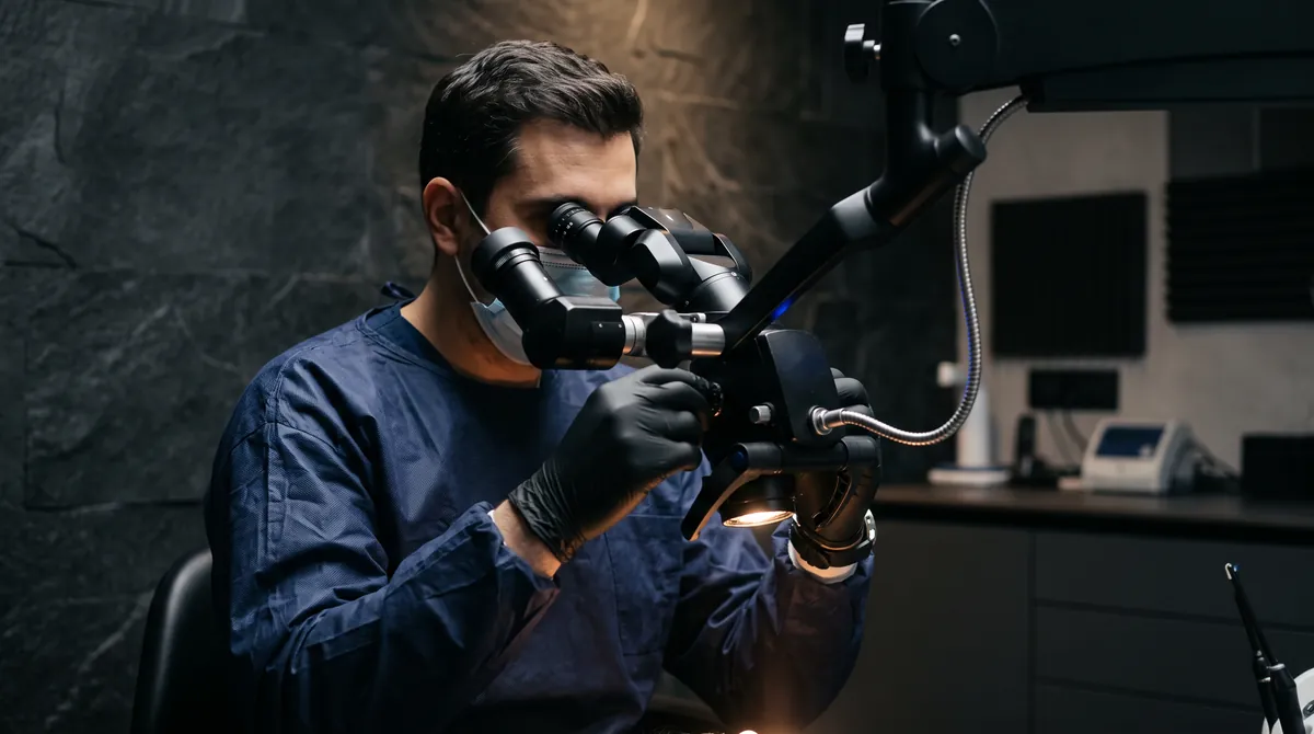 A dentist working at the operating microscope